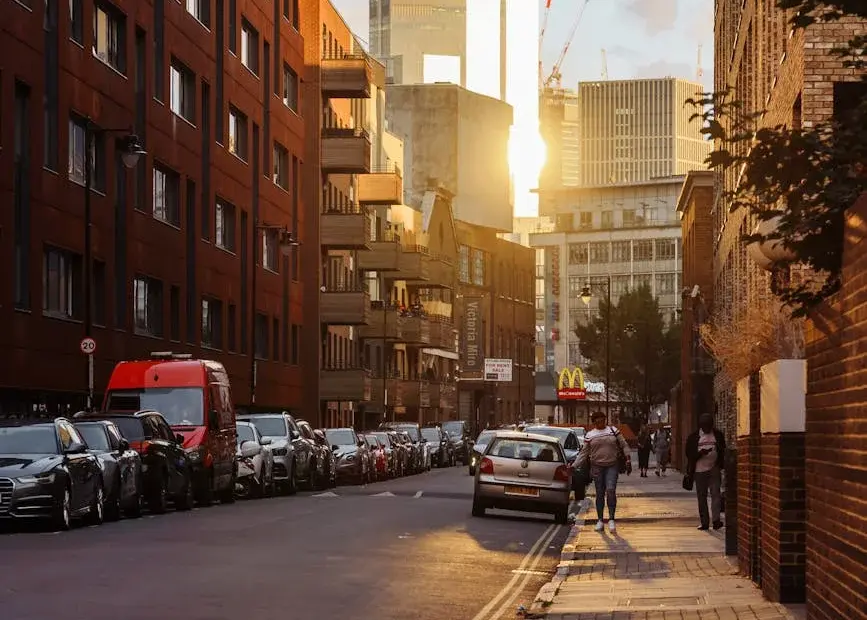 Urban street in London during a warm evening with pedestrians and a McDonald's sign.
