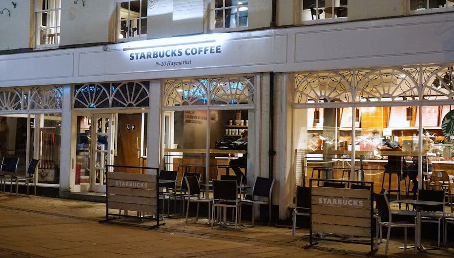 A cozy Starbucks café in Norwich with inviting exterior lights and seating at night.