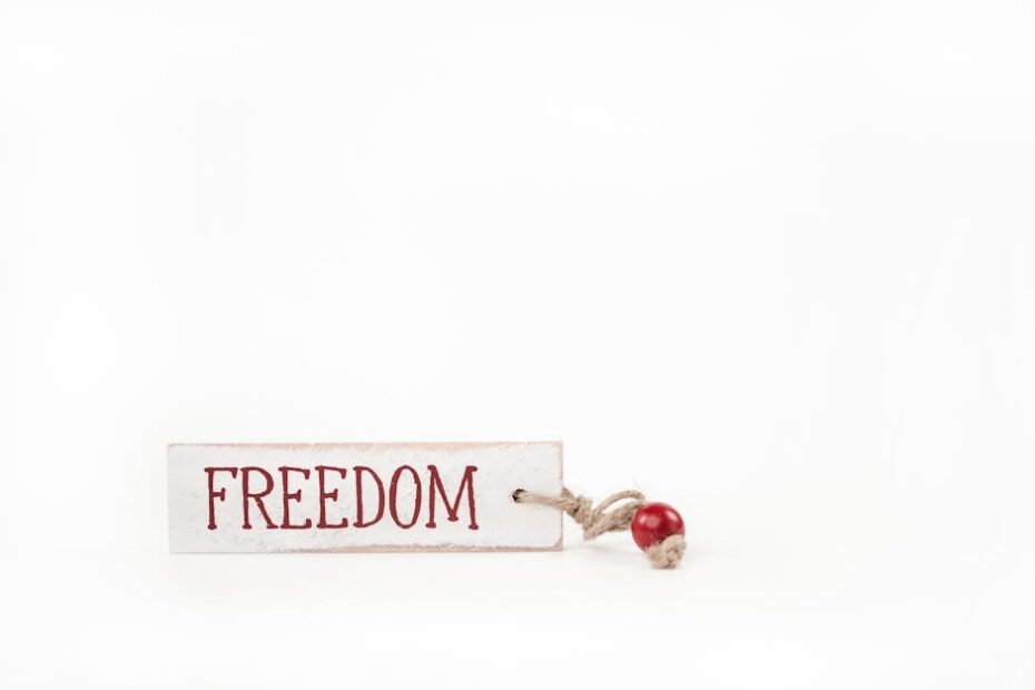 Simple and artistic display of freedom tag with red bead, conveying liberty and minimalism.