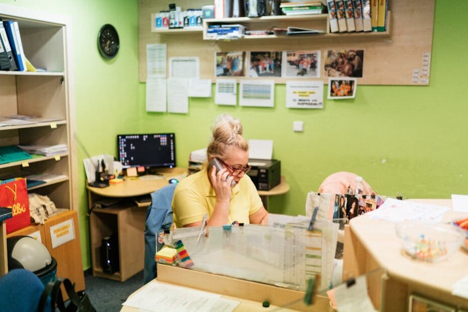 A caregiver talking on the phone at a nursing home reception desk in Karviná, Czech Republic.